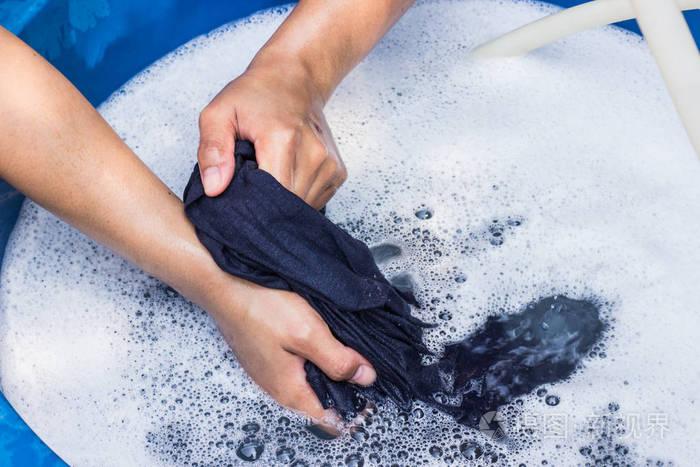 女性手洗衣物用洗涤剂在水池选择性聚焦和文本空间